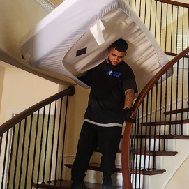 Professional luxury mover in Dallas taking mattress downstairs